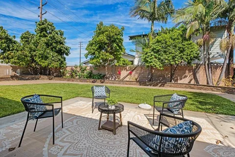 a view of a chairs and table in patio with a yard