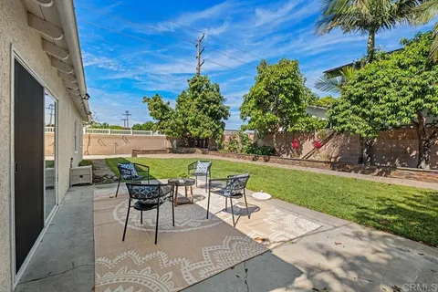 a patio with table and chairs and potted plants