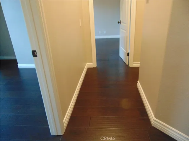 a view of a hallway with wooden floor and entryway