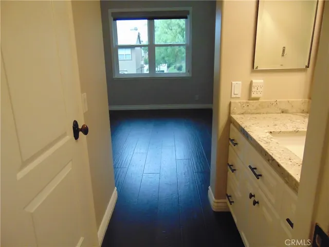 a bathroom with a granite countertop sink a toilet and a window