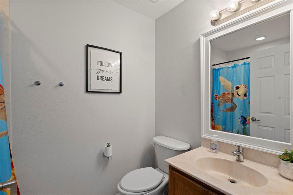 1461 Ridge Terrace Tarpon Springs, FL 34689 - Photo 23 of 25 a bathroom with a toilet sink and mirror