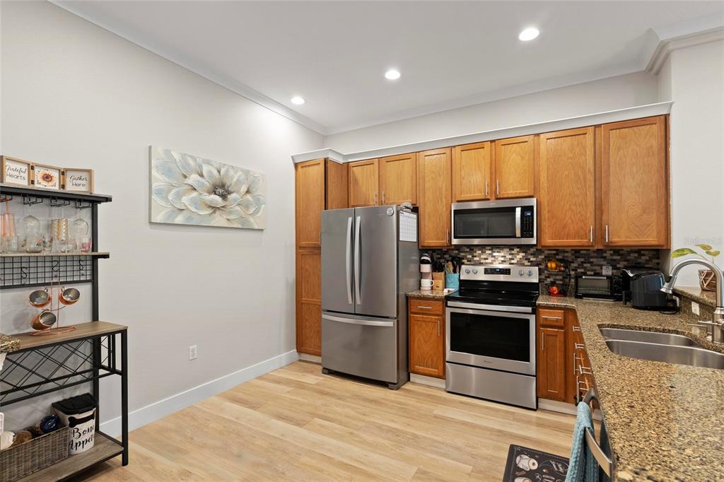 1461 Ridge Terrace Tarpon Springs, FL 34689 - Photo 6 of 25 a kitchen with stainless steel appliances a stove a refrigerator and a sink with wooden floor
