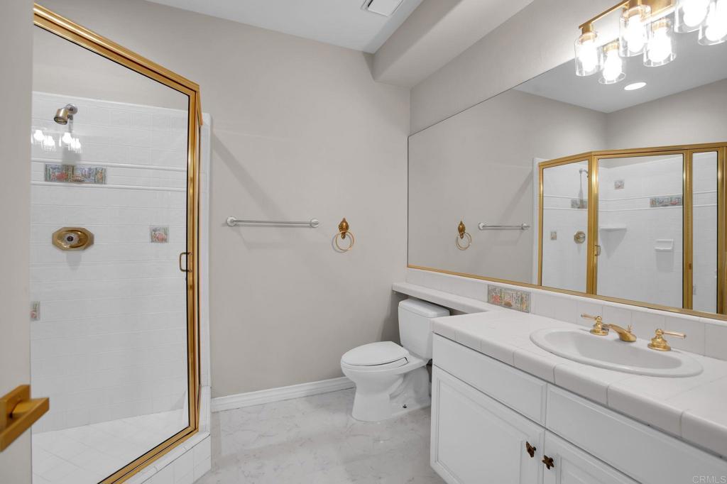 4286 La Canada Road Fallbrook, CA 92028 - Photo 27 of 60 a bathroom with a toilet a sink a mirror a shower and vanity