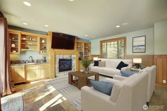 a living room with furniture a flat screen tv and a fireplace