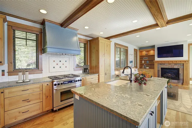 a kitchen with kitchen island granite countertop a stove and a sink