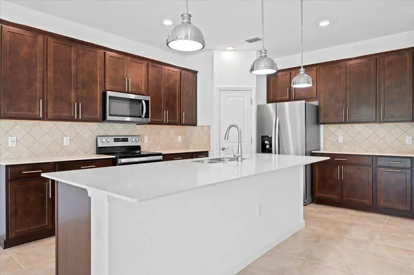 a kitchen with kitchen island a sink stainless steel appliances and cabinets