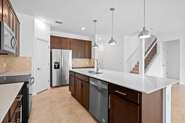 a kitchen with stainless steel appliances kitchen island a sink stove and refrigerator