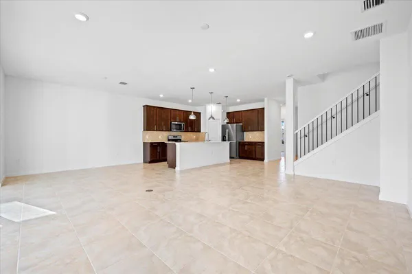 a view of a kitchen with a sink stove cabinets and empty room