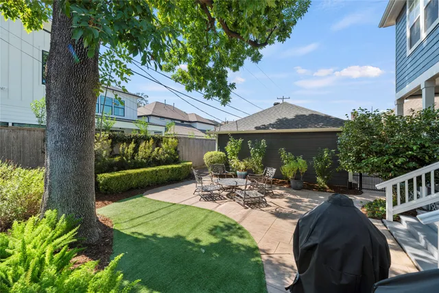 a view of backyard of house with outdoor seating and green space