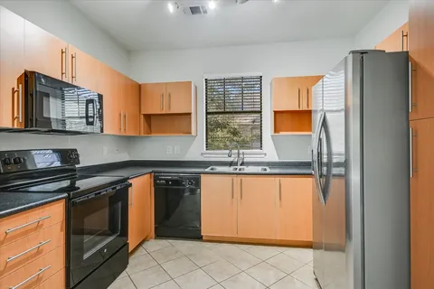 a kitchen with stainless steel appliances granite countertop a refrigerator and a sink