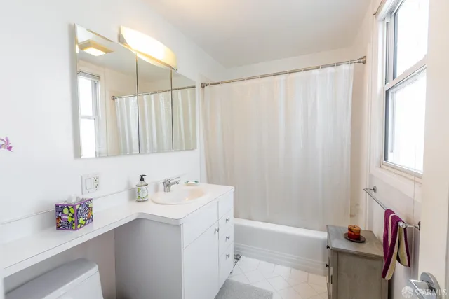 a bathroom with a sink vanity tub and a shower