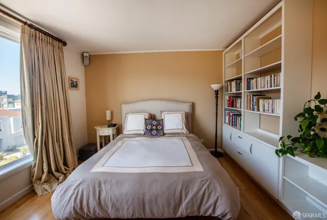 a bedroom with a bed and a book shelf