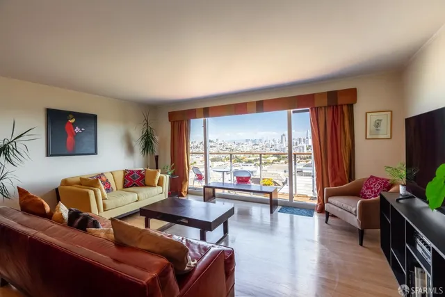 a living room with furniture a flat screen tv and a large window