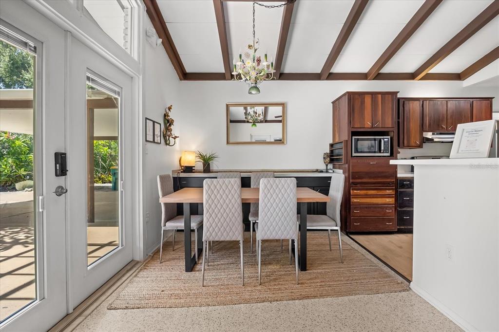 936 Santa Cruz Road Cocoa Beach, FL 32931 - Photo 5 of 45 a dining room with wooden floor a chandelier a wooden table and chairs