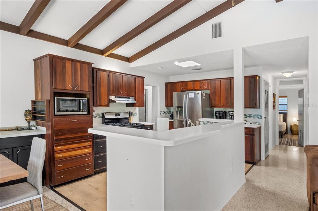 936 Santa Cruz Road Cocoa Beach, FL 32931 - Photo 6 of 45 a kitchen with stainless steel appliances kitchen island granite countertop a refrigerator a stove top oven a sink and dishwasher with wooden floor