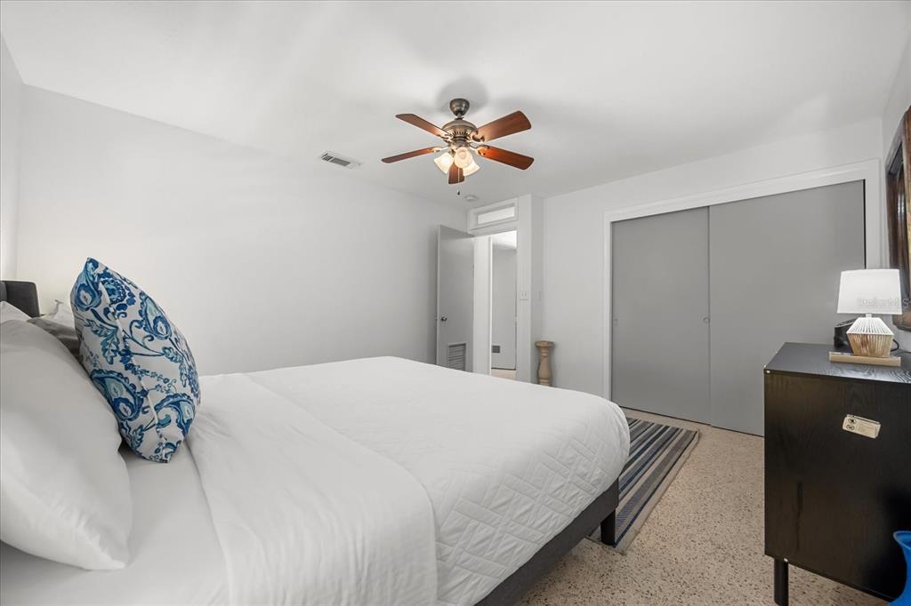 936 Santa Cruz Road Cocoa Beach, FL 32931 - Photo 10 of 45 a bedroom with a bed and a chandelier fan