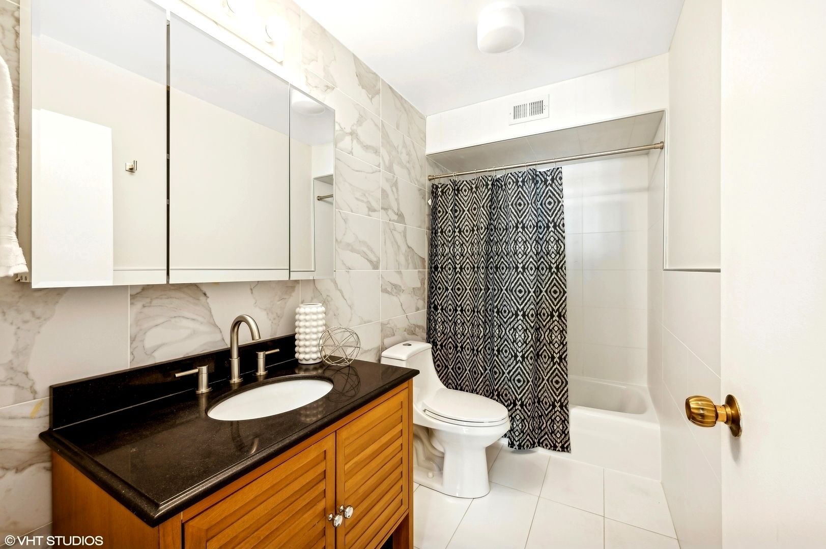6007 North Sheridan Road, Unit 21F Chicago, IL 60660 - Photo 11 of 22 a bathroom with a granite countertop sink a toilet a mirror and shower