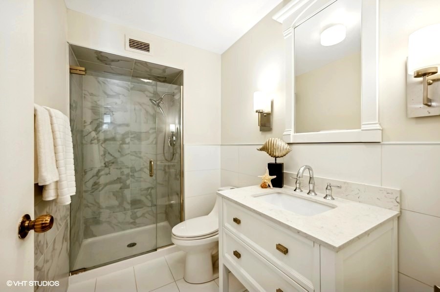 6007 North Sheridan Road, Unit 21F Chicago, IL 60660 - Photo 14 of 22 a bathroom with a sink mirror toilet and shower