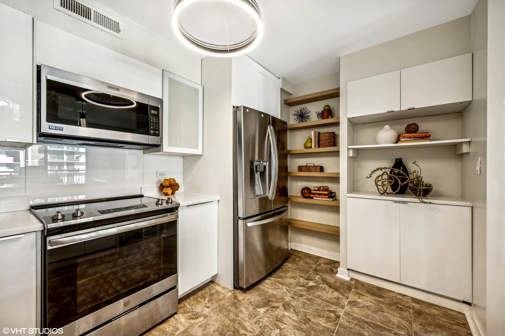 6007 North Sheridan Road, Unit 21F Chicago, IL 60660 - Photo 8 of 22 a kitchen with stainless steel appliances a stove a microwave and a refrigerator