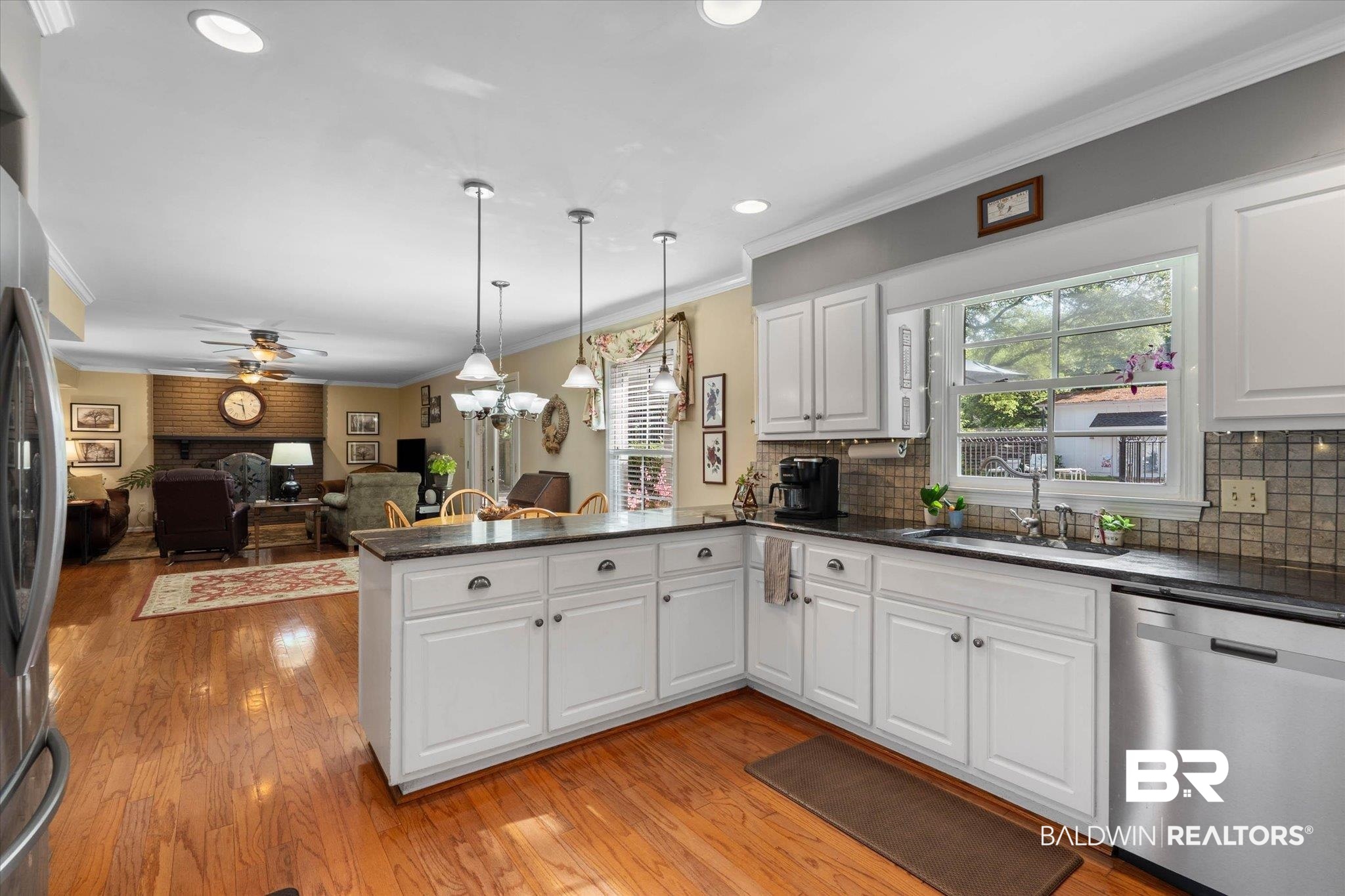559 East Cumberland Road Mobile, AL 36608 - Photo 17 of 48 Kitchen featuring stainless steel appliances, ornamental molding, white cabinetry, light wood finished floors, and a peninsula