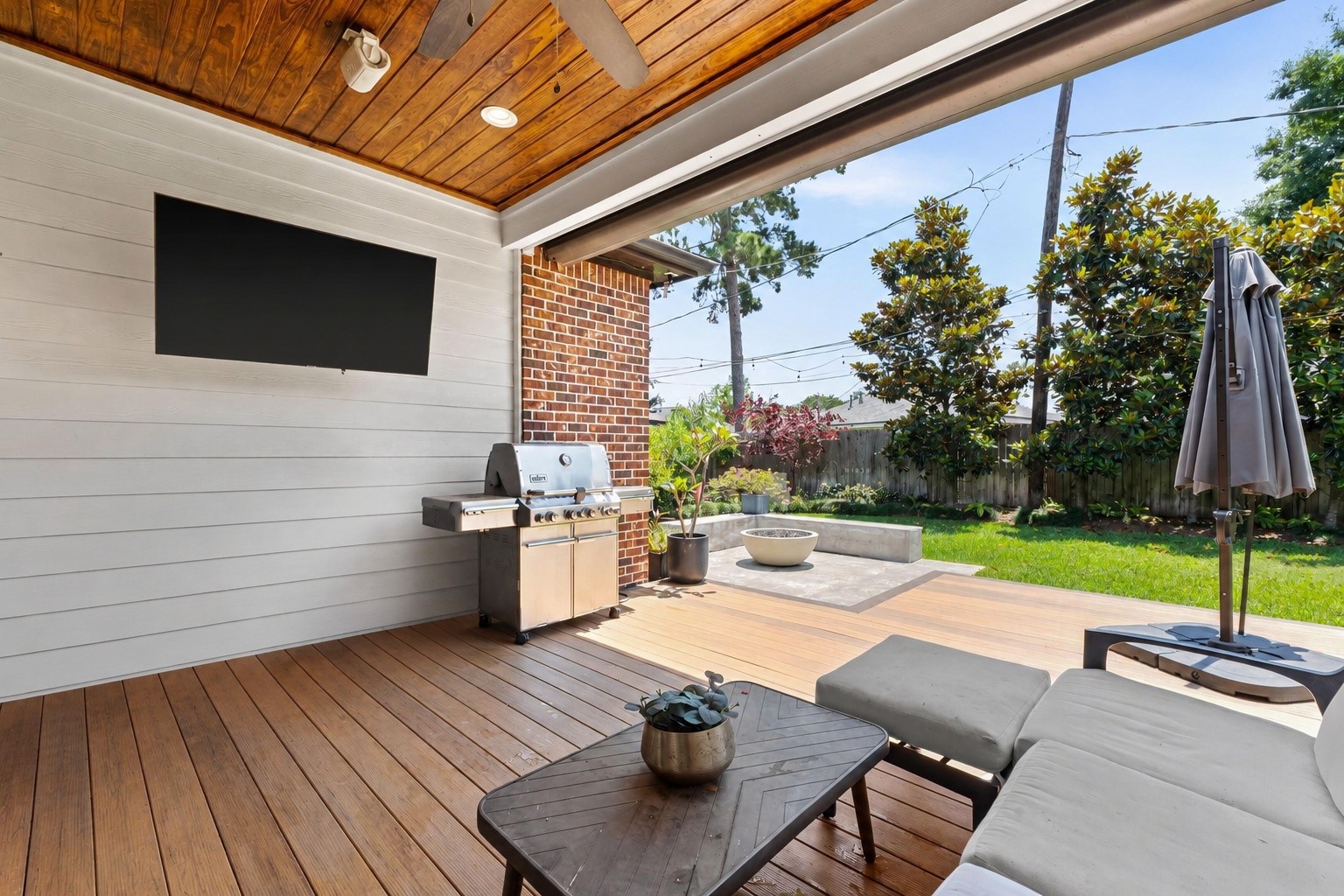 1013 Martin Street Houston, TX 77018 - Photo 38 of 46 Exceptional backyard retreat featuring a covered patio w/wood paneled ceiling, ceiling speakers, electronic shade, expansive entertaining patio, & dedicated fire pit area. Plenty of room for cooking out and dining al fresco!