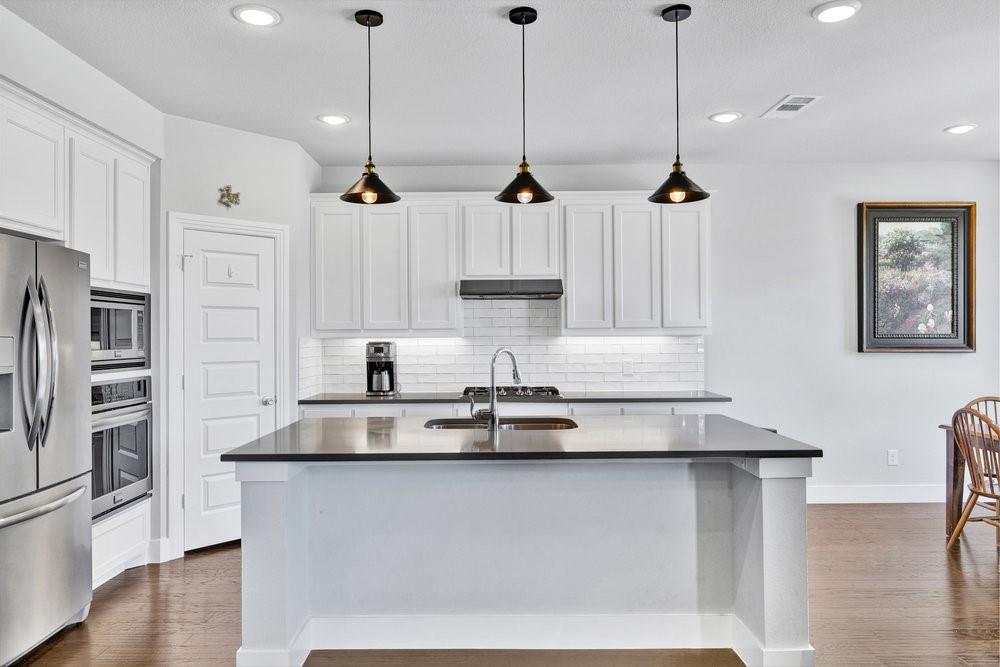 2044 Longbridge Road Forney, TX 75126 - Photo 12 of 40 a view of kitchen with stainless steel appliances granite countertop cabinets and wooden floor