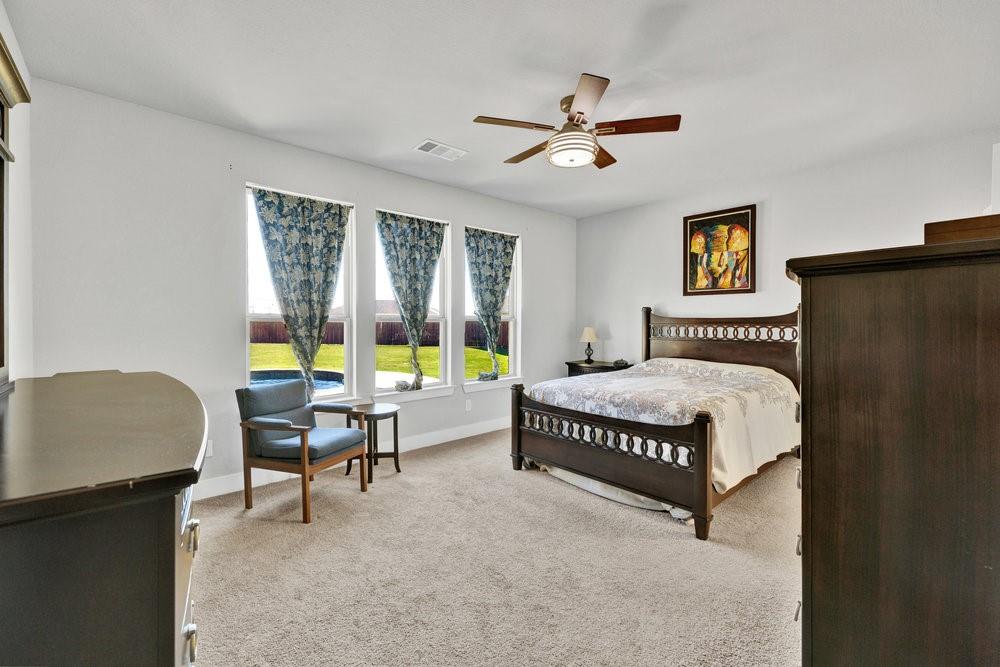 2044 Longbridge Road Forney, TX 75126 - Photo 16 of 40 a bedroom with a bed and a chandelier