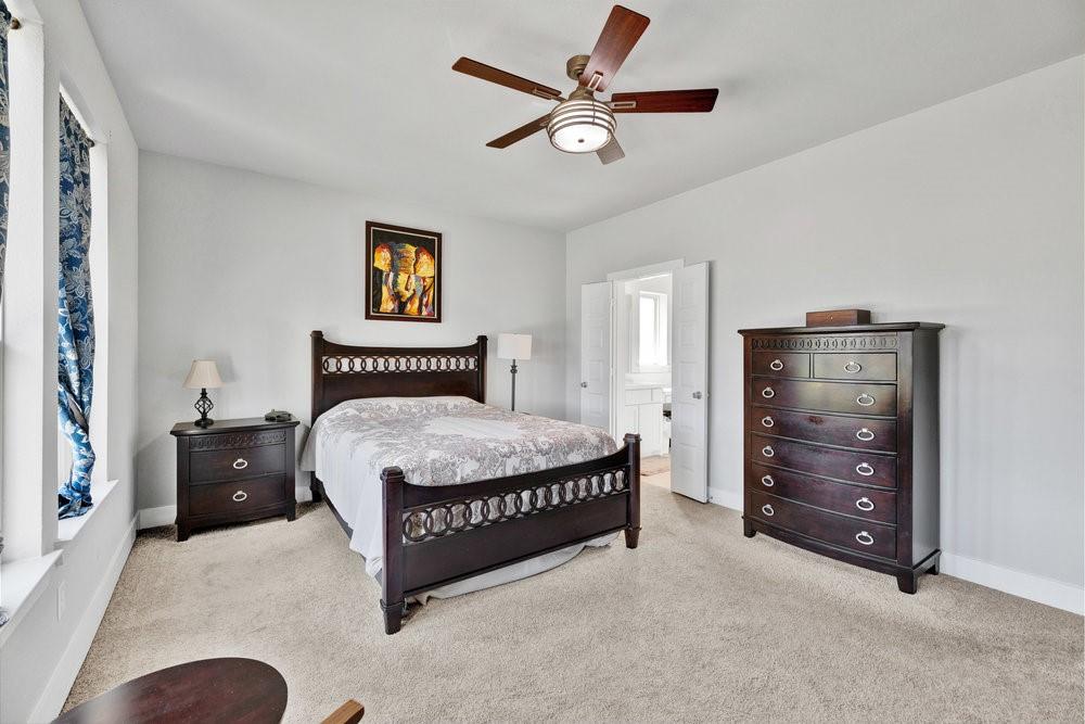 2044 Longbridge Road Forney, TX 75126 - Photo 17 of 40 a spacious bedroom with a bed and a ceiling fan