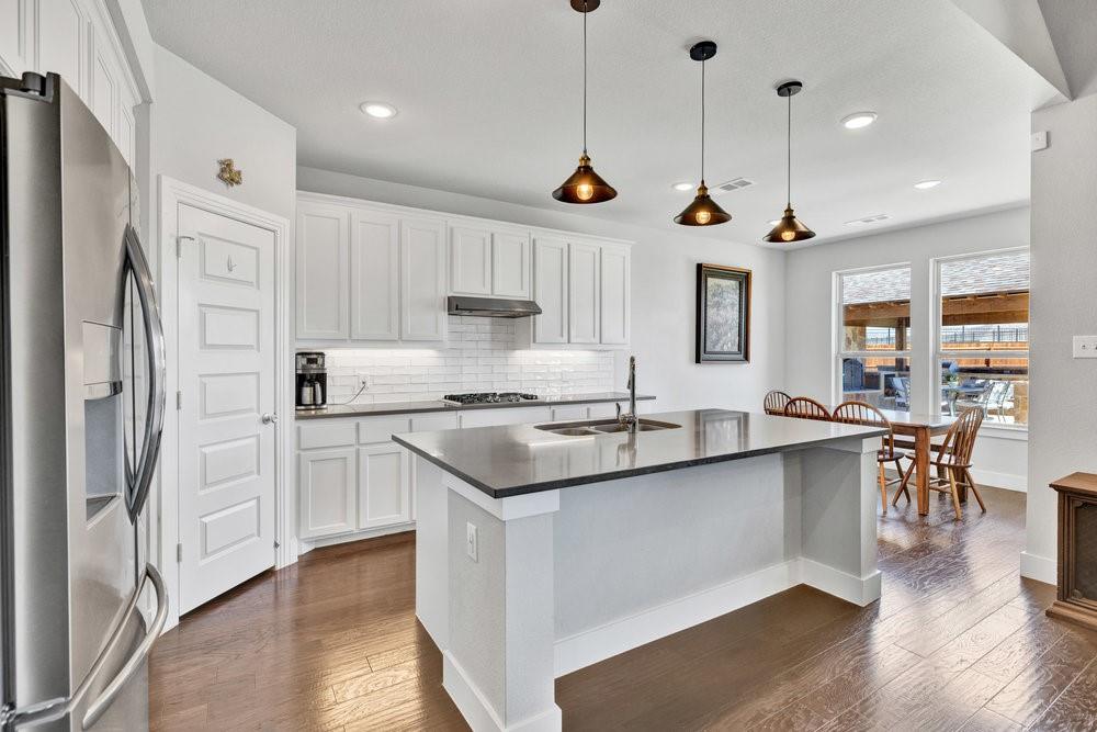 2044 Longbridge Road Forney, TX 75126 - Photo 10 of 40 a kitchen with stainless steel appliances granite countertop a sink a stove a refrigerator and island with wooden floor