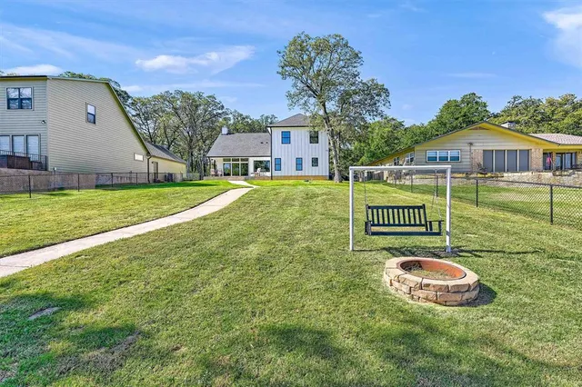 a view of a big house with a big yard and large trees