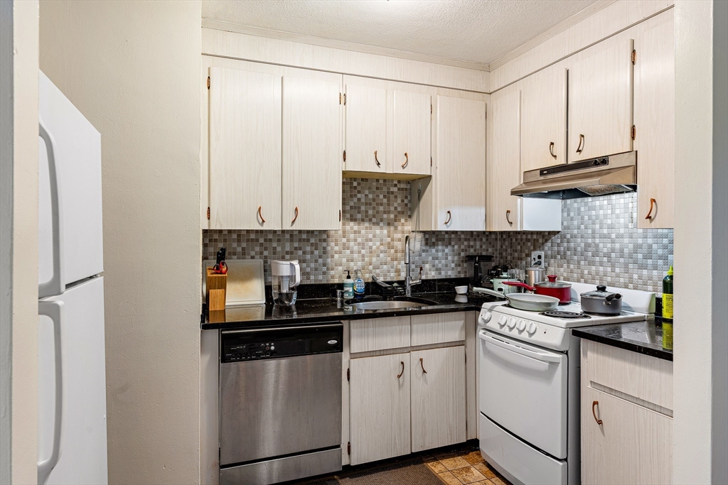 10 Scottfield Road, Unit 34 Boston, MA 02134 - Photo 15 of 19 a kitchen with stainless steel appliances granite countertop a refrigerator sink and cabinets