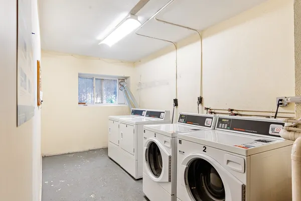 a view of washer and dryer with bathroom in the background