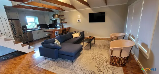 a kitchen with stainless steel appliances granite countertop a refrigerator a stove and a wooden floors