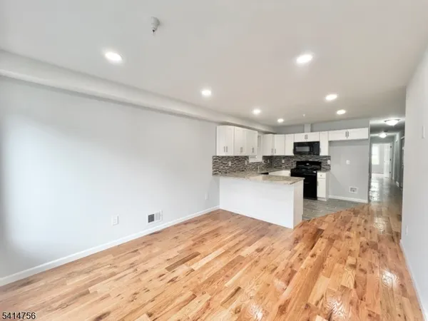 a large kitchen with kitchen island sink refrigerator and white cabinets