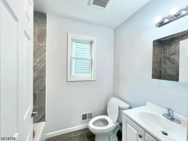 a white toilet sitting next to a bathroom sink
