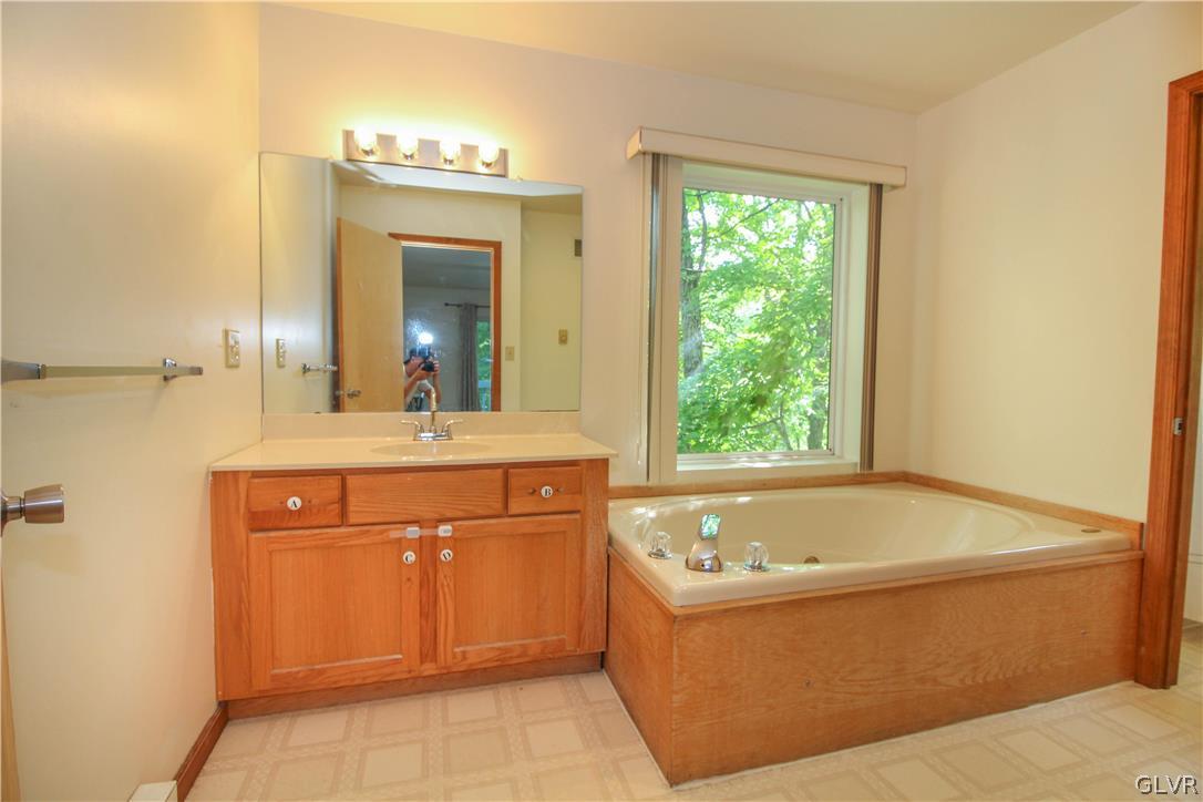 4219 Winchester Way Bushkill, PA 18324 - Photo 22 of 49 a bathroom with a tub sink and mirror