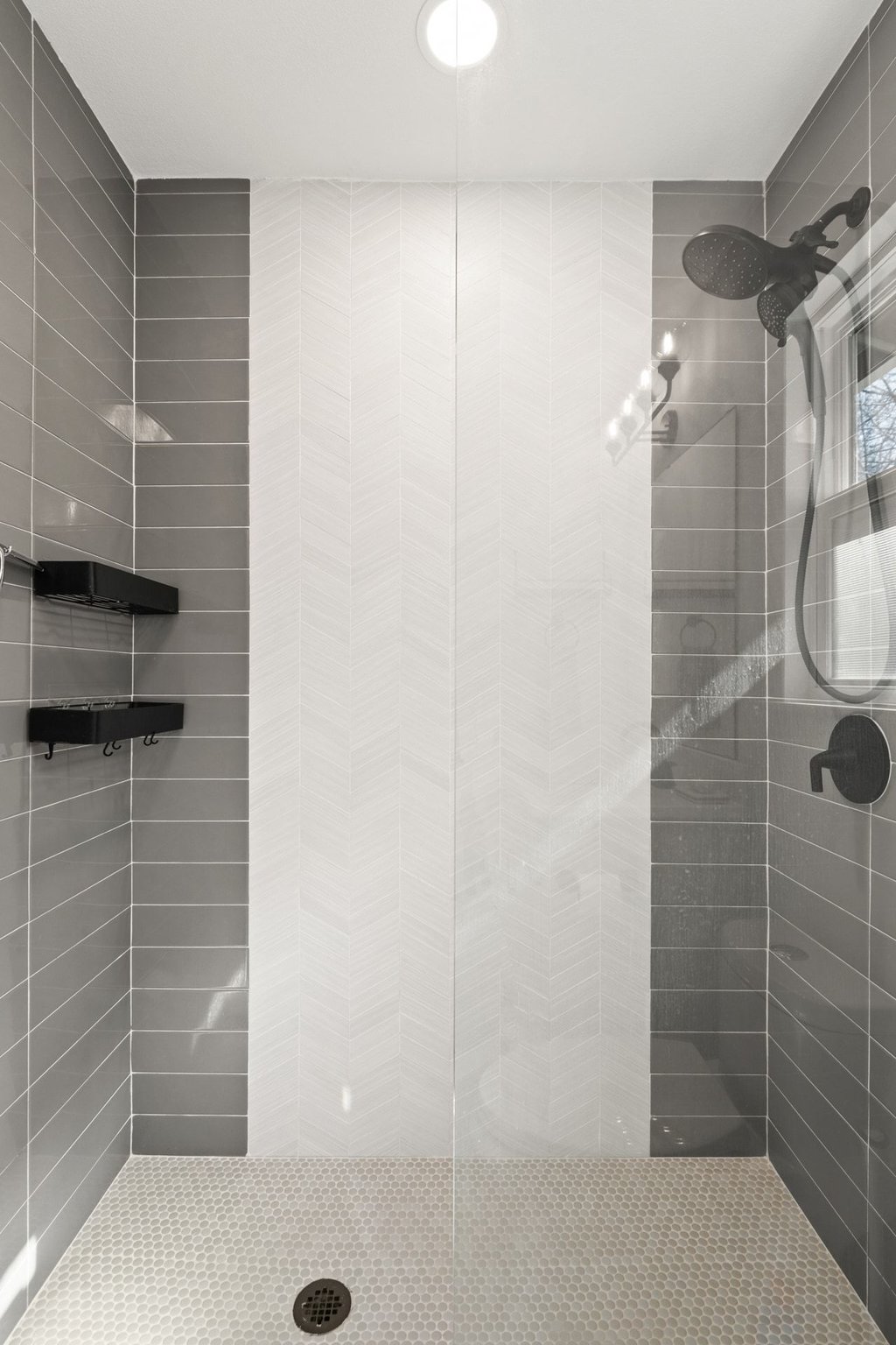 4705 Old Castle Road Austin, TX 78745 - Photo 22 of 32 It features a quartz vanity and oversized walk-in shower with floor to ceiling tile surround incljuding an accent herringbone pattern.