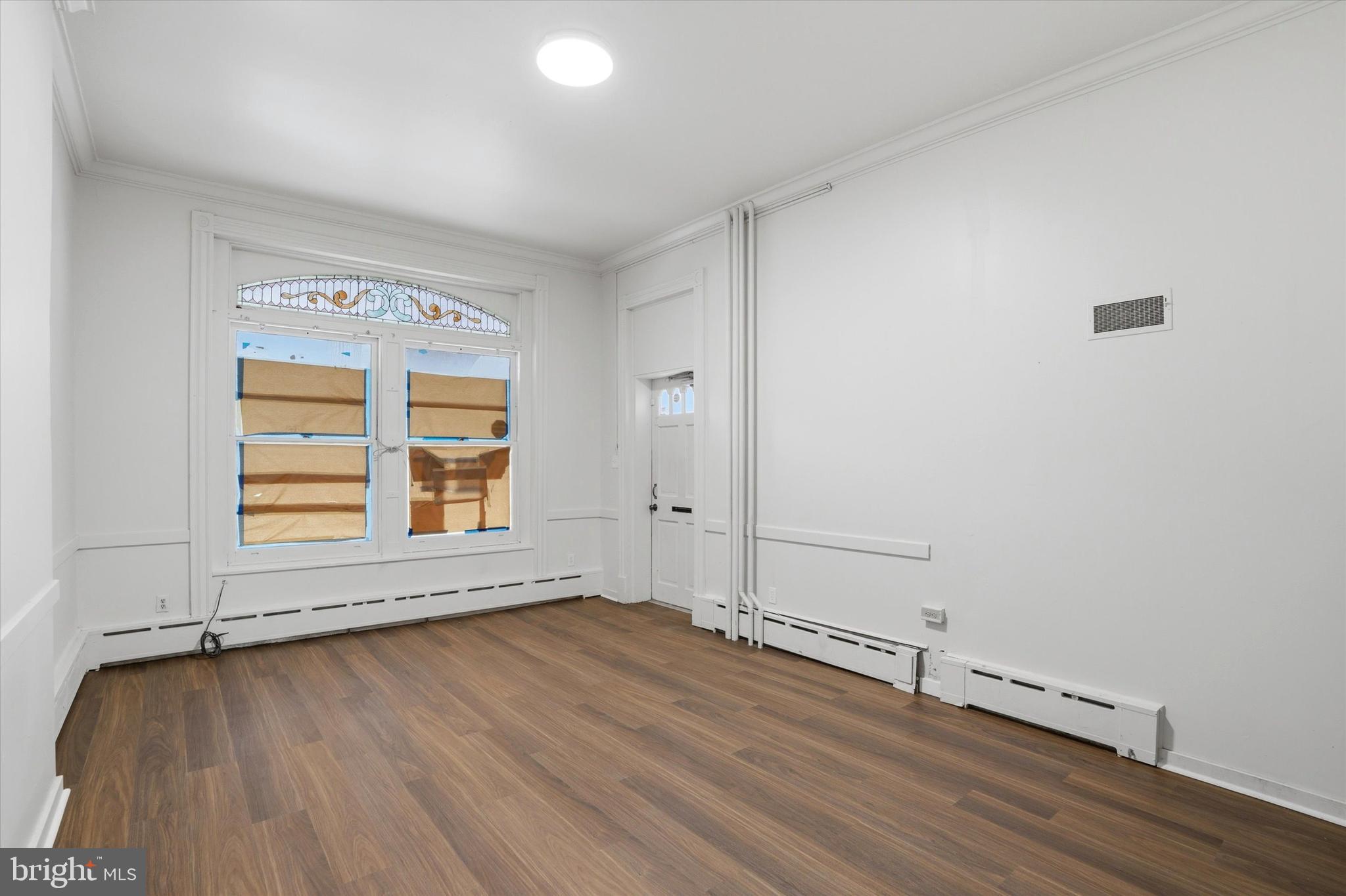112 North 11th Street, Unit 1 Reading, PA 19601 - Photo 3 of 17 an empty room with wooden floor and windows