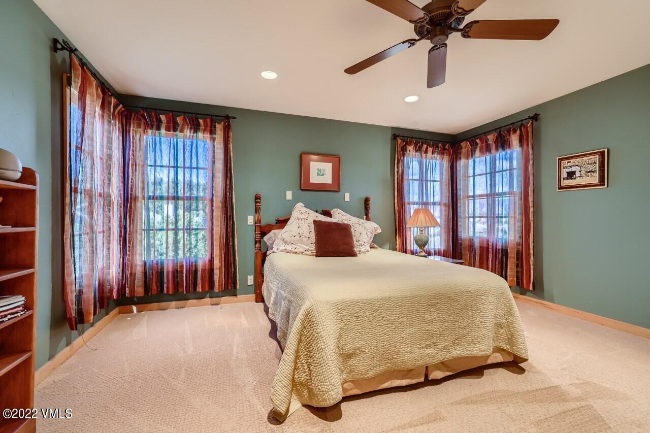 417 Neilson Gulch Road Eagle, CO 81631 - Photo 14 of 28 a bedroom with a large bed and a chandelier