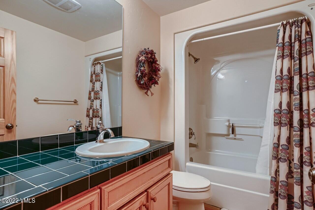 417 Neilson Gulch Road Eagle, CO 81631 - Photo 23 of 28 a bathroom with a granite countertop sink toilet a mirror and shower