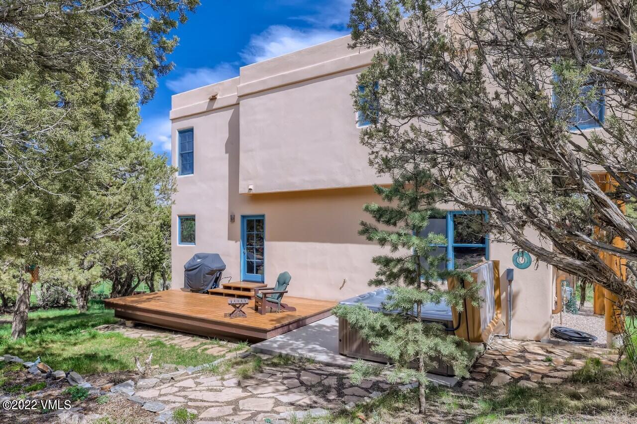 417 Neilson Gulch Road Eagle, CO 81631 - Photo 27 of 28 a backyard of a house with table and chairs under an umbrella