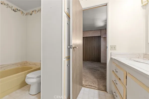 a bathroom with a granite countertop toilet a sink and bathtub