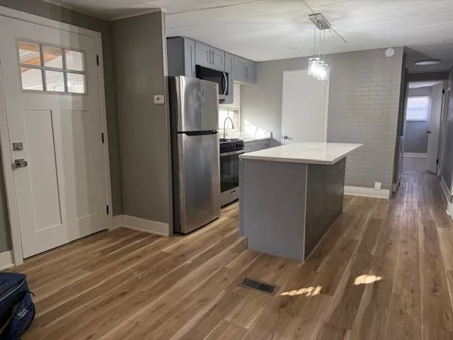 a kitchen with kitchen island a counter top space and a refrigerator