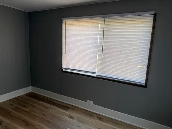 a view of a small space with wooden floor and a window