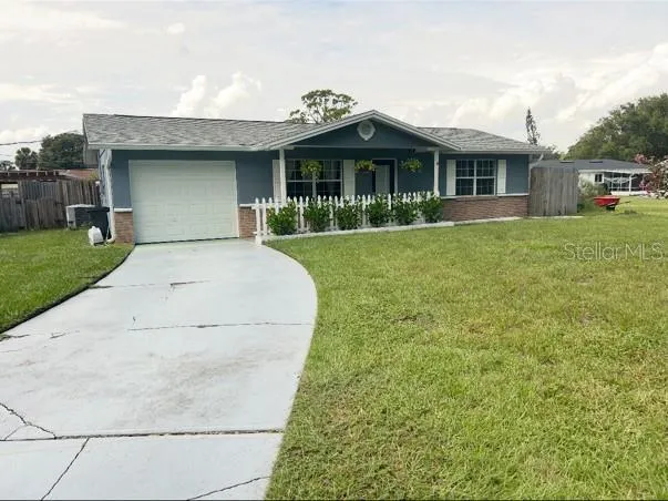 a view of a white house with a yard and potted plants