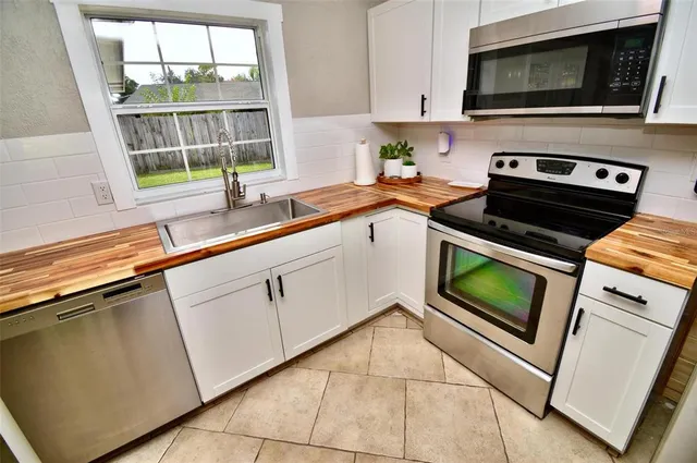 a kitchen with stainless steel appliances a stove a sink and a refrigerator