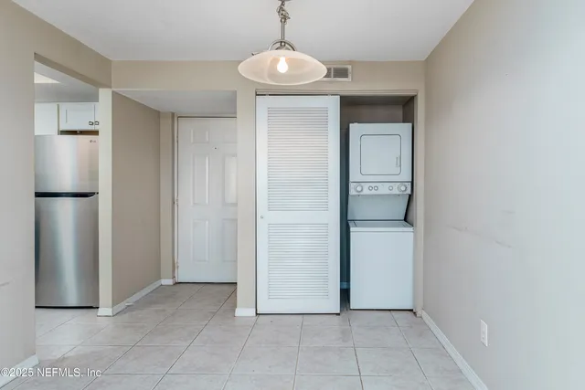 a view of a refrigerator in kitchen and an empty room