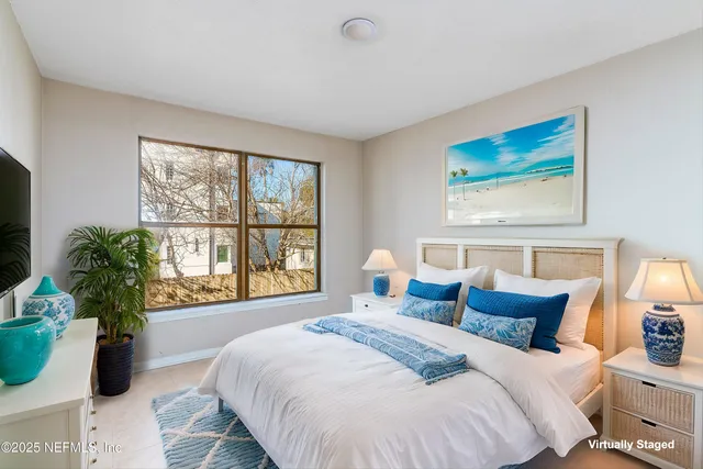 a bedroom with furniture and a large window