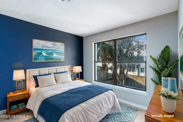 a bedroom with a large bed and a potted plant