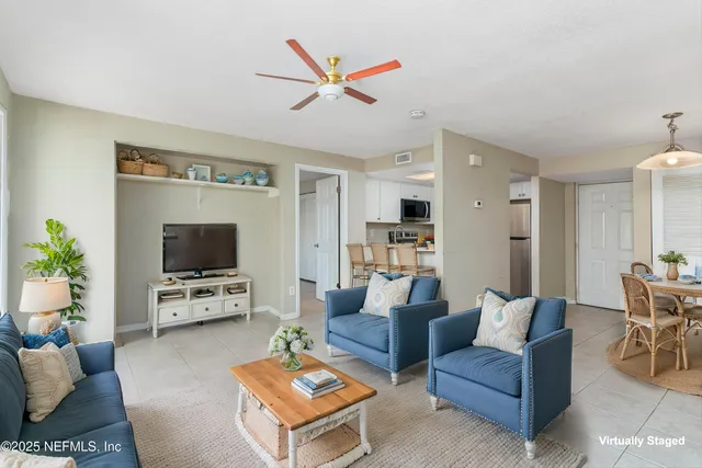 a living room with furniture a flat screen tv and a dining table